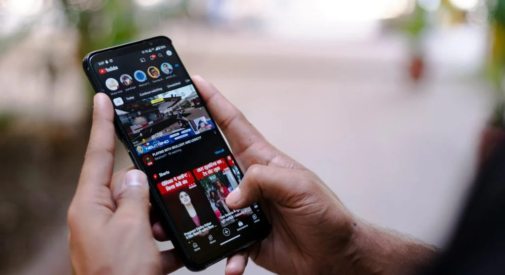 Person holding a smartphone with a 5G network speed indicator on the screen