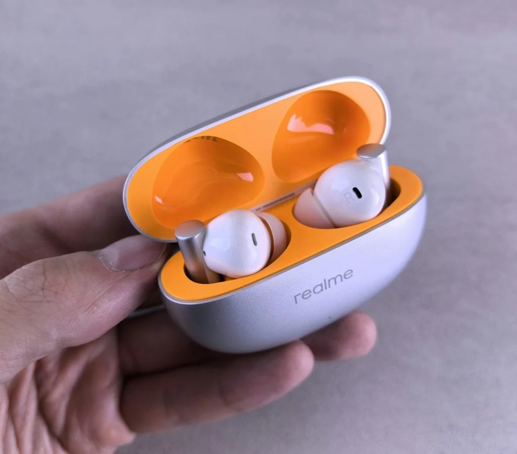 Person holding wireless earbuds checking noise cancellation feature