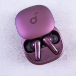 Person holding multiple wireless earbuds for comparison