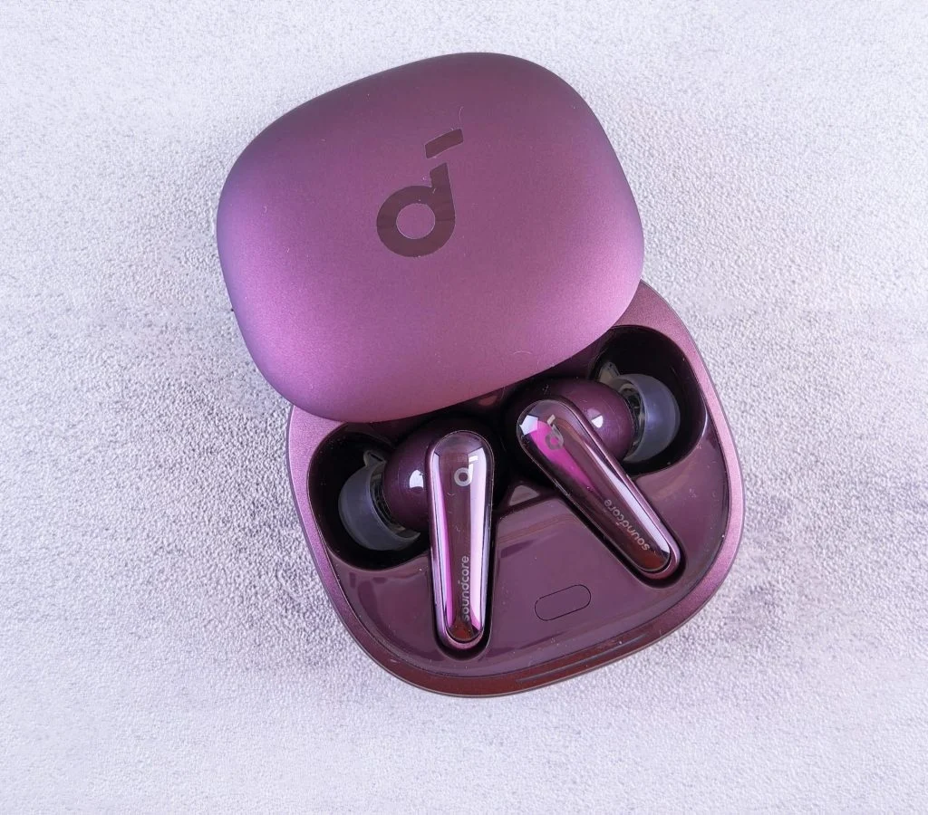 Person holding multiple wireless earbuds for comparison