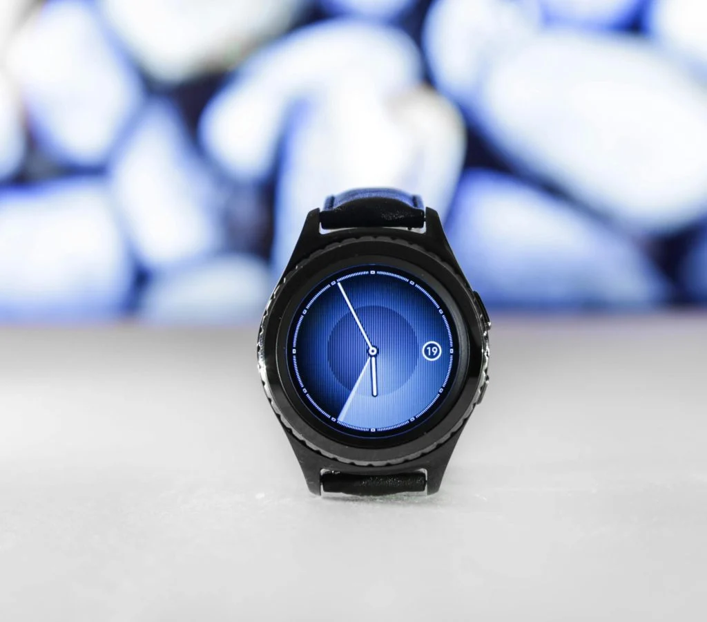person holding several smartwatches with different designs and brands