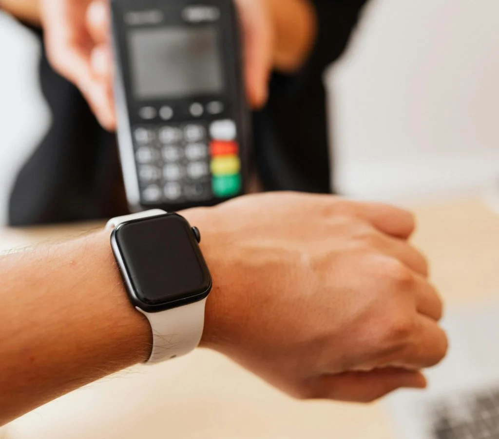 Person holding a smartwatch and a smartphone to check compatibility