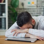 person holding phone with tired expression