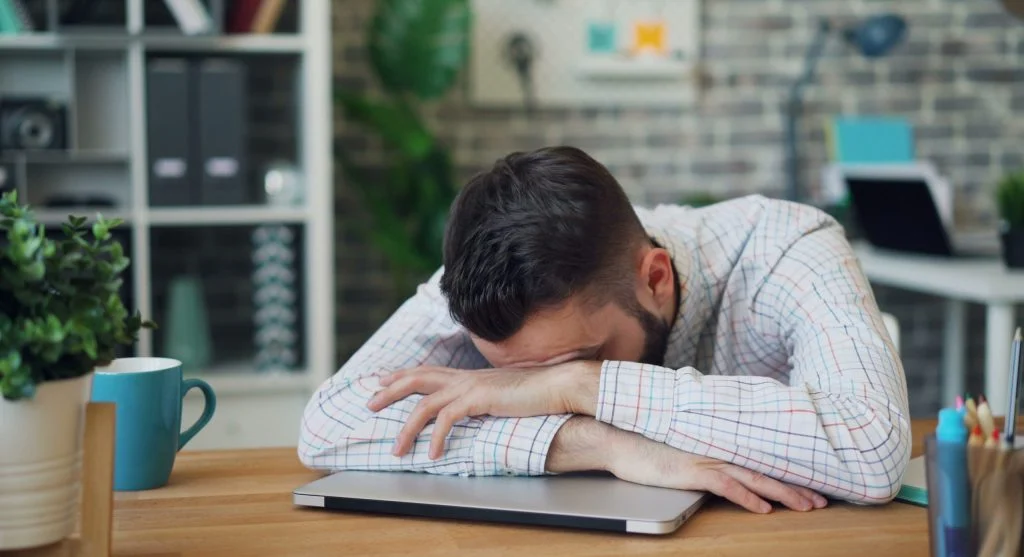 person holding phone with tired expression